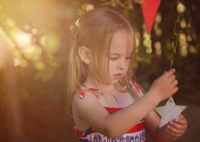 little girl holding a star decoration by Samantha Brown Photography