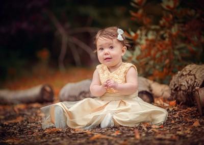 Little girl sitting on autumn leaves by Samantha Brown Photography