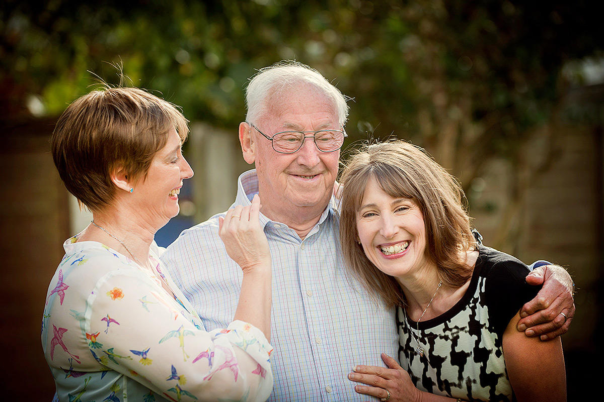 father with his two daughters laughing by Samantha Brown Photography