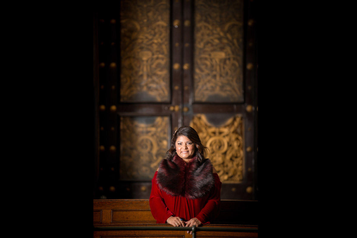 portrait of woman in front of ornate doors